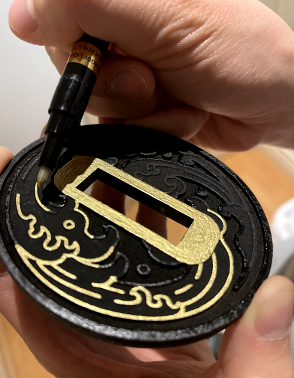 Image of me contouring gold color along the tsuba's symble pattern.